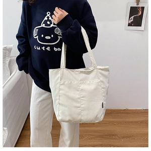 Détail du sac fourre-tout en velours côtelé blanc avec texture rayée et poche