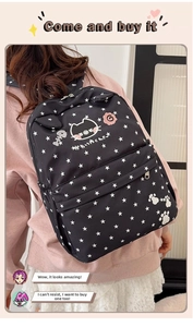 Close-up of black backpack featuring white star patterns and cute cat embroidery details