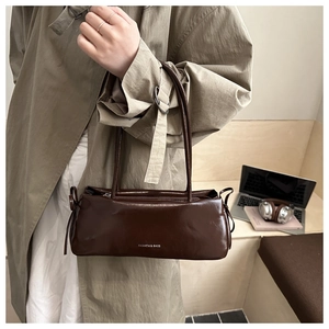 Détail du sac baguette marron foncé en cuir poli avec impression du logo