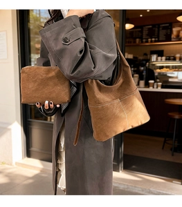 Detailed view of brown suede tote bag and matching pouch in a casual city setting
