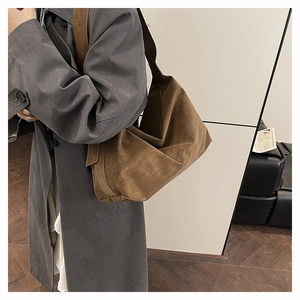 Close-up of deep brown suede tote bag featuring a minimalist slouchy design and wide strap