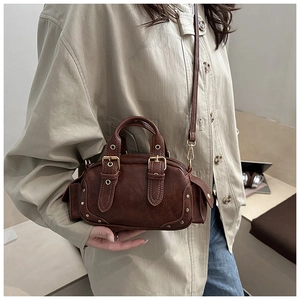 Detail shot of vintage dark brown leather bowling bag showing side pockets and gold hardware