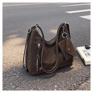 Detail of dark brown faux suede hobo bag with adjustable strap and small matching pouch