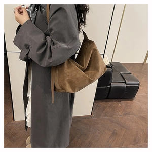 Dettaglio della borsa hobo in pelle scamosciata marrone scuro con trama morbida e capiente