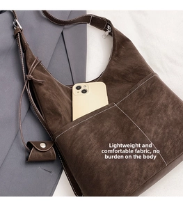 Close-up of vintage tote bag featuring contrast stitching and external phone pocket