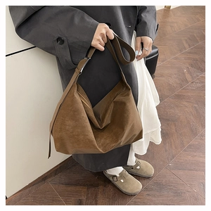 Dettaglio di una grande borsa a tracolla in pelle scamosciata marrone con cerniera hobo