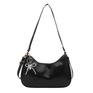 Glossy black leather hobo shoulder bag with a silver beaded bow charm on a white background