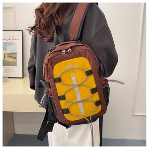 Détail du grand sac à dos de voyage marron avec panneau jaune et cordons décoratifs noirs