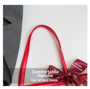 Close-up of the comfortable handle and red satin bow with golden wedding pattern