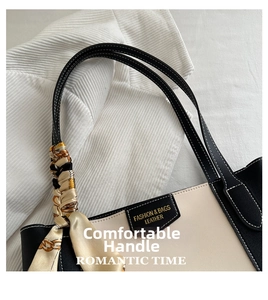 Detailopname van de contrasterende leren handtas met witte stiksels en zijden sjaaltje