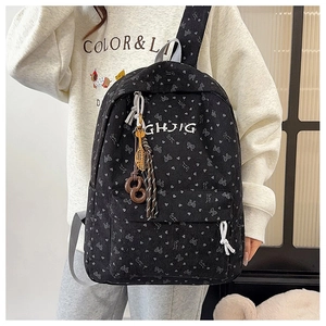 Detail von Cord-Rucksack mit Herzprint und dekorativen Schläger-Anhängern an der Seite