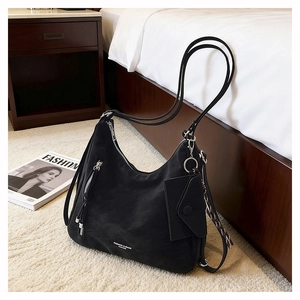 Macro detail of black hobo bag with suede texture, dual zippers and detachable mini pouch