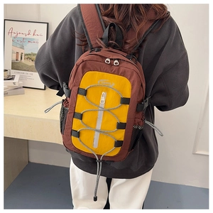 Détail de sac à dos de voyage avec cordons élastiques croisés et poches latérales filet