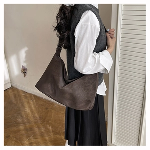 Detail of dark brown suede hobo tote bag shown on model for autumn winter commute outfit