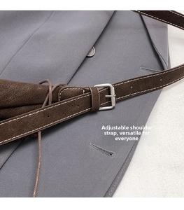 Close-up of dark brown leather adjustable strap with white stitching and silver buckle
