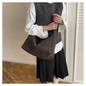 Vista dettagliata della borsa hobo caffè scuro con texture vintage su una modella