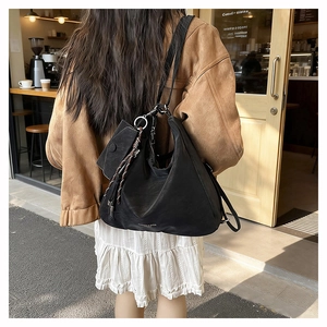 Outdoor shot of the adjustable strap and metallic buckles on the black hobo shoulder bag