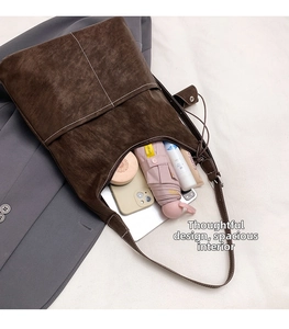 Detail showing the large capacity of this dark brown tote bag with various daily essentials