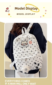 Rear view of white cat and star backpack with plush star pendant on a female model