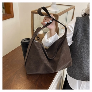 Detail of dark brown faux leather tote with adjustable shoulder strap and silver buckle