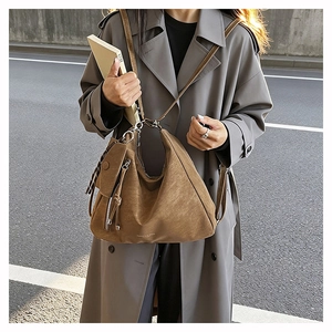 Close-up of brown matte leather hobo bag with minimalist white brand lettering logo