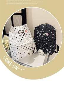 Detail of star pattern backpacks with cute cat ears and fuzzy pompom keychains