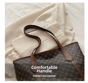 Detail shot of a large vintage tote bag with classic brown monogram print and leather straps