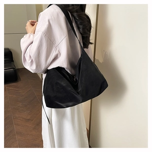 Minimalist black hobo shoulder bag shown on model for size and drape perspective