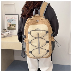 Détail d'un sac à dos de voyage kaki avec cordon élastique et poches latérales en filet