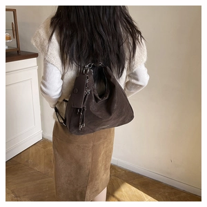 Detailed back view of a dark brown matte tote backpack with side metal zipper decoration