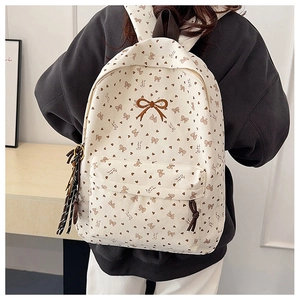 Detailansicht des Cord-Rucksacks mit brauner Schleifenstickerei und Herzmuster-Print