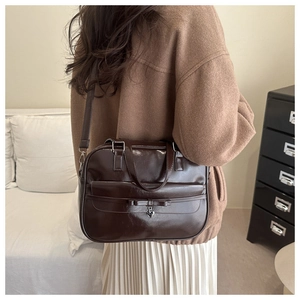 Detail of dark brown tote bag with bow and heart pendant shown in a home setting