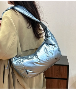 Dettaglio della borsa trapuntata blu metallizzato con tracolla larga e finitura lucida