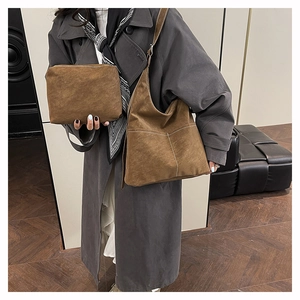 Close-up of brown matte tote and matching clutch with stylish white contrast stitching