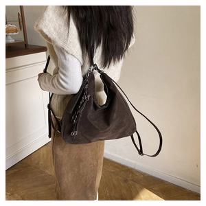 Detail of soft dark brown leather hobo bag with textured finish and zipper closure