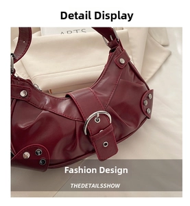 Detail view of burgundy leather handbag with vintage pleats, silver studs and buckles