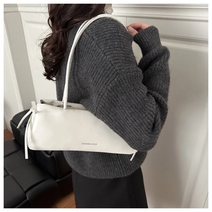 Détail de la texture en cuir PU blanc et de la bandoulière du sac minimaliste chic