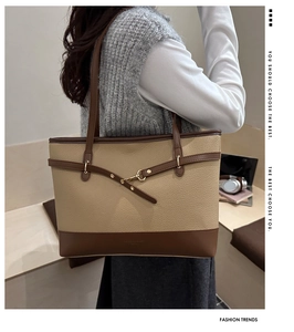Detail of contrast color tote bag showing lychee grain leather and metal buckle detail