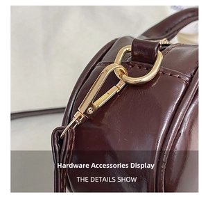 Detail of glossy brown leather handbag with premium gold lobster clasp and D-ring hardware