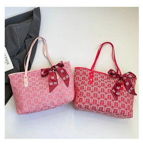 Detail of red and pink woven tote bags with festive Xi characters and velvet bows