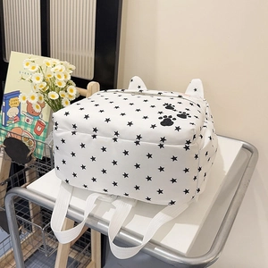 White backpack with star print and cute cat ears shown in a bright lifestyle setting