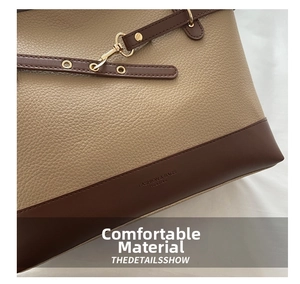Detailed macro view of litchi texture leather and golden metal buckle on tote bag