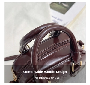Detailed macro view of dark brown glossy leather handles with gold D-ring hardware