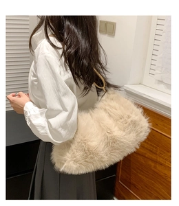 Detail of plush cream shoulder bag featuring fluffy faux fur texture and gold chain handle