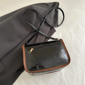 Retro Boston shoulder bag in black glossy material with brown trim and slim strap
