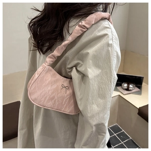 Detail of pink pleated satin armpit bag with silver bow accent and ruffles