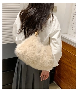 Detail of beige faux fur shoulder bag with woven metal strap on a model outfit