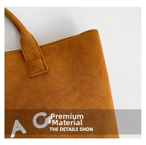 Close-up of brown suede tote bag showing reinforced stitching and premium soft texture