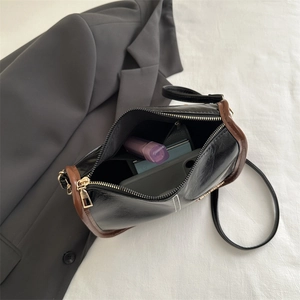 Minimalist black and brown crescent Boston bag with adjustable strap and golden zipper