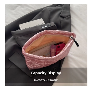 Detail view of pink quilted satin cosmetic bag showing large interior storage capacity